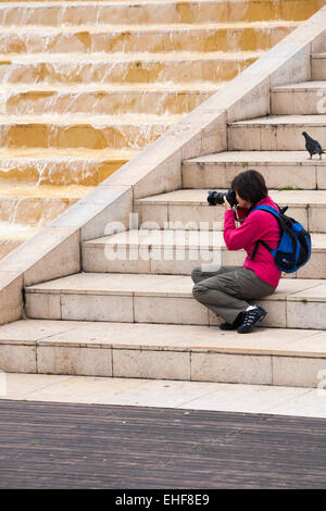 woman taking photo of water cascading over Cascade Steps, Bristol in May Stock Photo