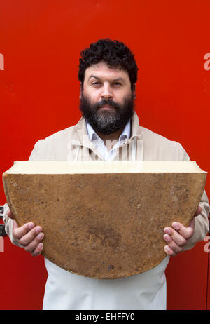 Portrait of cheese maker carrying hard cheeses - Stock Image - F023/1666 -  Science Photo Library