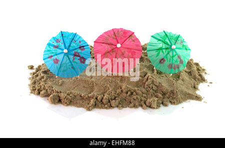 green blue red cocktail Umbrellas in Sand Mound Stock Photo