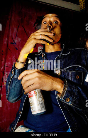 Guy smoking a spliff and having a beer at a squat party London. Stock Photo