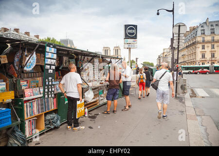 Paris, France - August 07, 2014: Small souvenir shops with walking tourists on the Seine river embankment in Latin quarter of Pa Stock Photo