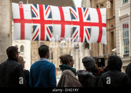 King Street, London, UK. 13th March, 2015.  Thousands of members of the public cheer on as ceremonial flags hang overhead to greet members of the armed forces marching from St. Paul's en route to Guildhall after attending a service to commemorate those who took part in the war in Afghanistan. Credit:  Stephen Chung/Alamy Live News Stock Photo