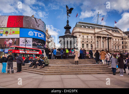 Piccadilly Circus, London, England, with the statue of Eros, crowds of tourists and a red London bus, on a sunny winter day. Stock Photo