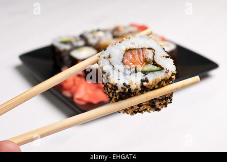 Sushi on a black plate on white table. Stock Photo