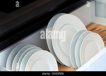 Porcelain plates in a modern kitchen drawer Stock Photo