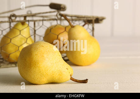 Fresh ripe pears in metal basket on table Stock Photo