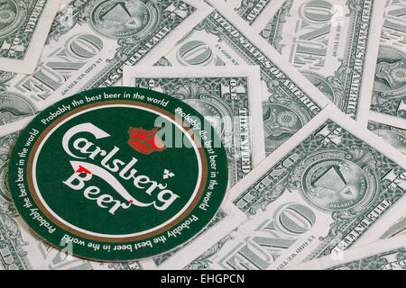 England, London - November 11, 2014:Beermat from Carlsberg beer and US dollars.The Carlsberg is a Danish brewing company founded Stock Photo