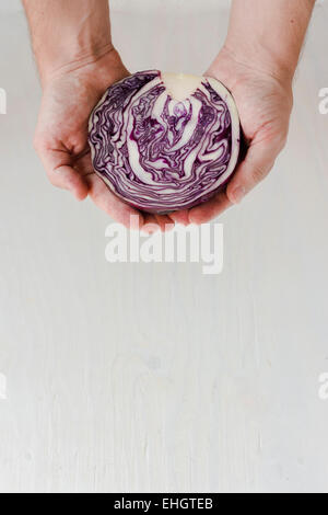 Young man holding half a red cabbage. Complexity. Stock Photo