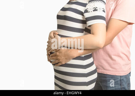 Pregnant couple. Husband touching his wife belly with hands Stock Photo