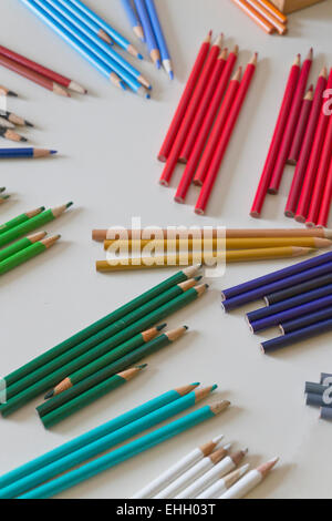 Colored pencils lying on a table carefully sorted by color and hue Stock Photo