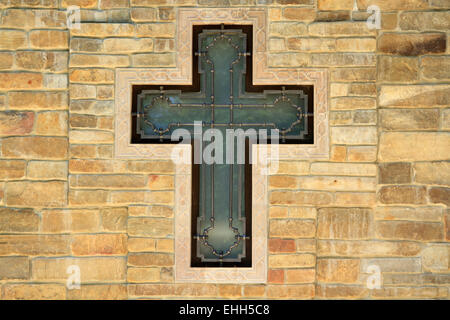 decorative metal cross on textured wall Stock Photo