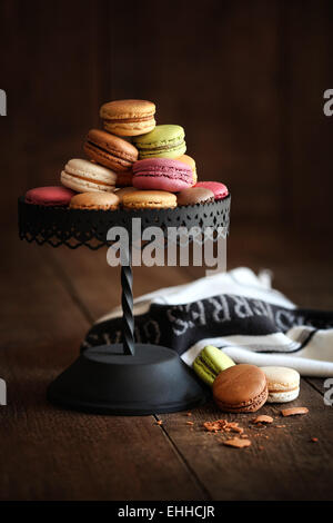 Cake stand with macaroons on dark wood Stock Photo