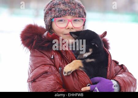 Pet's owner, children and dogs concept - little girl lying on the floor ...