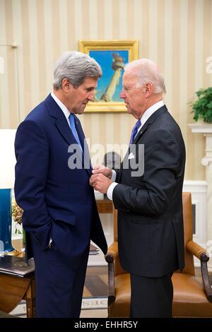 US Vice President Joe Biden talks with Secretary of State John Kerry in the Oval Office of the White House October 1, 2014 in Washington, DC. Stock Photo