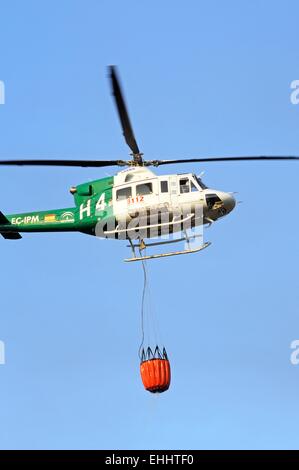 Bell 412 registration EC-IPM carrying water for fire fighting, Cabopino Golf, Costa del Sol, Malaga Province, Andalucia, Spain, Stock Photo