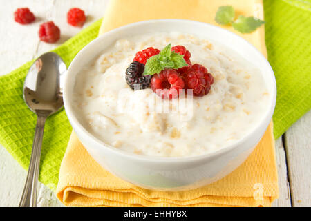 Fresh hot oatmeal porrige with raspberry and mint on napking and wooden table, close up, horizontal. Healthy vegetarian summer b Stock Photo