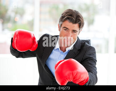 Furious businessman wearing boxing gloves Stock Photo