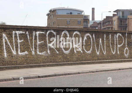 Graffiti wall on a bridge 'Never Grow up' Stock Photo