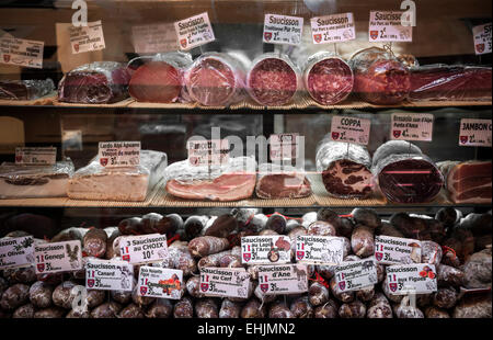 NICE, FRANCE - OCTOBER 2, 2014: Cured meats on display in butcher shop on Rue Pairoliere, a quaint pedestrian shopping street. Stock Photo