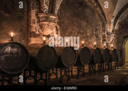 Old wine barrels in wine-cellar with candles Stock Photo