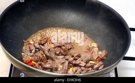 cooking beef with red chilly in a black frying pan Stock Photo