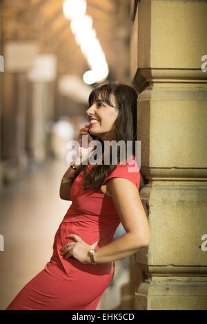 A happy smiling woman in her 40's talking on her mobile device in the old part of the city Stock Photo