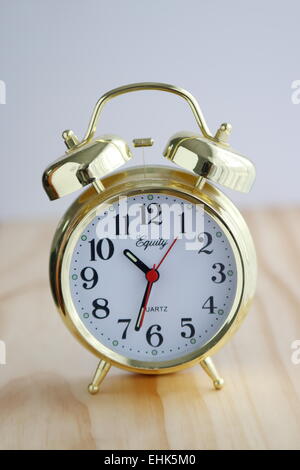 Golden clock on a wooden board Stock Photo