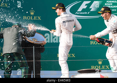 Albert Park, Melbourne, Australia. 15th Mar, 2015. Lewis Hamilton (GBR) #44 (1st) and Nico Rosberg (DEU) #6 (2nd) spray champagne at Jackie Stewart on the podium at the 2015 Australian Formula One Grand Prix at Albert Park, Melbourne, Australia. Sydney Low/Cal Sport Media/Alamy Live News Stock Photo