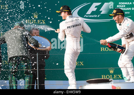 Albert Park, Melbourne, Australia. 15th Mar, 2015. Lewis Hamilton (GBR) #44 (1st) and Nico Rosberg (DEU) #6 (2nd) spray champagne at Jackie Stewart on the podium at the 2015 Australian Formula One Grand Prix at Albert Park, Melbourne, Australia. Sydney Low/Cal Sport Media/Alamy Live News Stock Photo