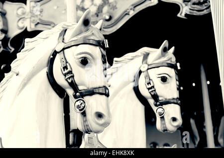 closeup of two horses in a nostalgic carousel, filtered in black and white Stock Photo