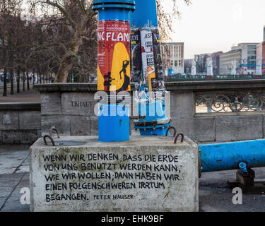 Concrete block supporting blue water drainage pipe inscribed with quotation by Peter Hauser - Mitte, Berlin Stock Photo