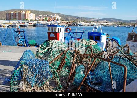 Traditional Spanish fishing boats in the harbour with fishing nets in the foreground, Puerto de la Atunara, Spain. Stock Photo