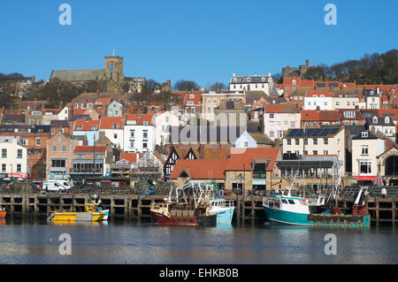 Fishing boats moored in Scarborough harbour, with the old town and castle in the background, North Yorkshire, UK Stock Photo