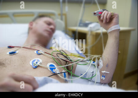 A man in hospital connected to an ECG heart monitor Stock Photo
