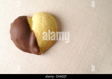 Heart shaped chocolate dipped cookie over linen Stock Photo