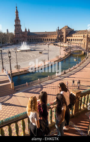 Group of four girls, friends, tourists, looking down on Plaza de Espana Seville, Sevilla, Spain in early spring. Stock Photo