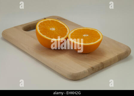 Oranges to Orange Juice.  The whole fruit to homemade juice.  Cut oranges on cutting board. Stock Photo