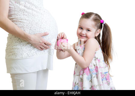 Pregnant mother and kid putting coins into piggy bank Stock Photo