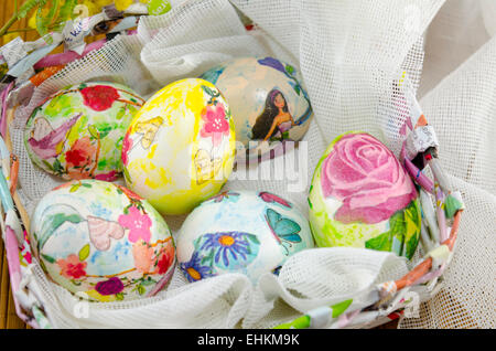 Bunch of hand colored Easter eggs in a handmade paper egg basket Stock Photo