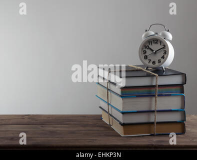 alarm clock stand on a pile of books Stock Photo