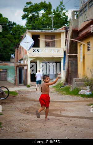 A boy flies a homemade kite in the street in Trinidad, Cuba Stock Photo