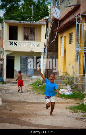 A boy flies a homemade kite in the street in Trinidad, Cuba Stock Photo