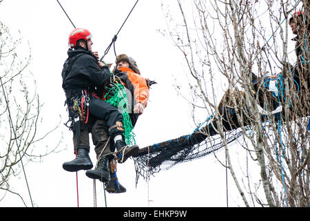 Bristol, UK. 15th Mar, 2015. A specialist eviction climber lowers a protester to the ground ready to be evicted.  A fourth day of evictions from a protest site, occupied to prevent work starting on a Metrobus project, saw the tree-top camps cleared and protesters evicted. Bristol, UK. 15th March 2015. Credit:  Redorbital Photography/Alamy Live News Stock Photo