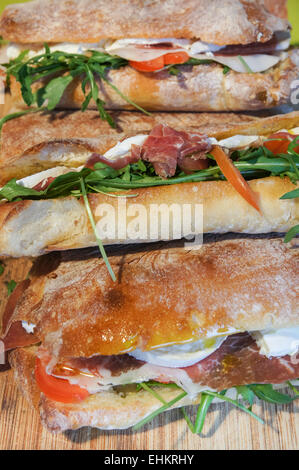 Ciabatta sandwich with wild rocket, prosciutto ham, tomatoes and mozzarella Stock Photo