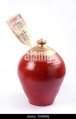 Earthen pot is a coin box of rural India called Gullak, with one thousand rupees. Stock Photo