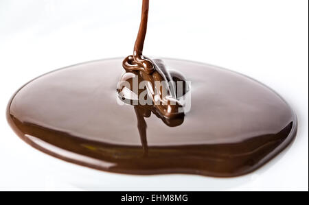 Chocolate flow isolated on white background close up Stock Photo