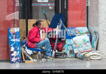 Homeless artist living and painting in former Bank doorway in Las Palmas, Gran Canaria, Canary Islands, Spain Stock Photo