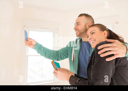 Mixed race couple selecting color swatches in new home Stock Photo