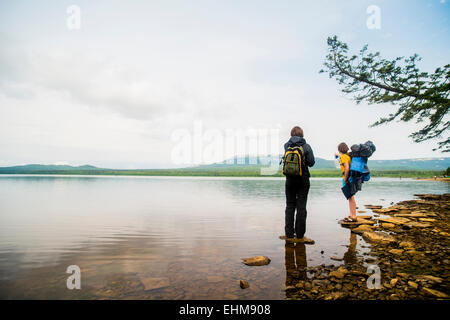 Caucasian couple backpacking near rural lake Stock Photo