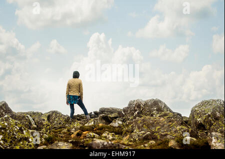 Caucasian hiker standing on rocky hilltop Stock Photo